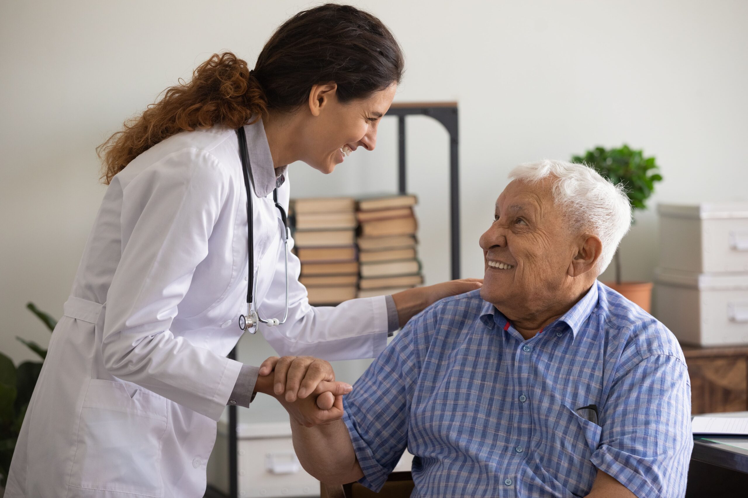 Female doctor talking to senior man patient, both smiling